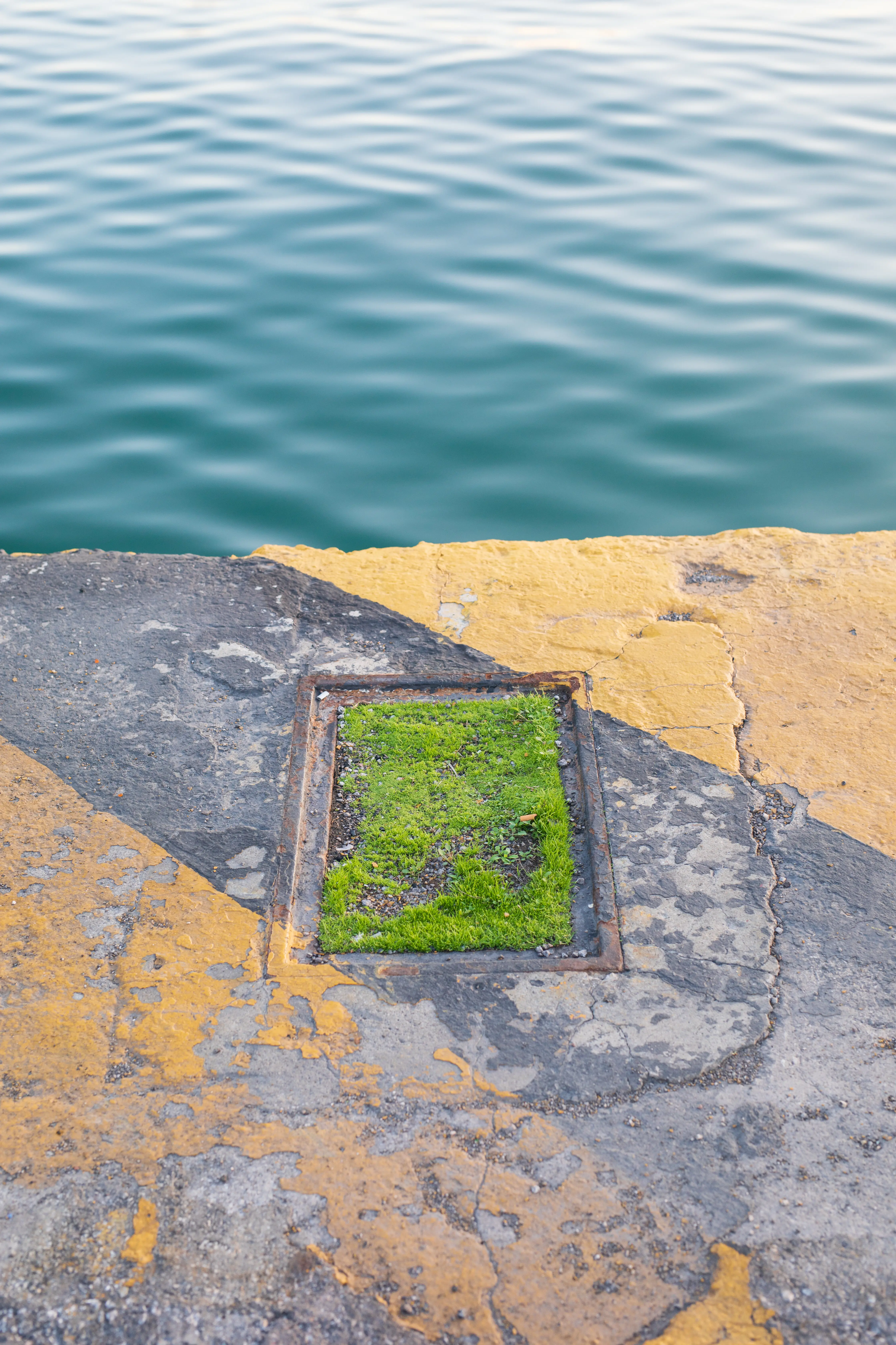 A view from above of a yellow wall next to a lake.